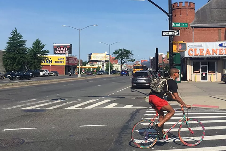 Person biking at intersection between Atlantic Avenue and Franklin Avenue in Brooklyn, New York City